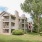 Apartment building exterior surrounded by grass and trees
