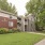 Apartment building with red siding surrounded by trees